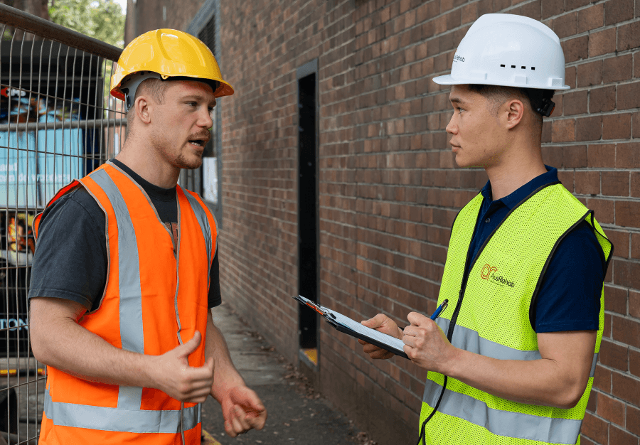 Workplace rehab consultant discussing job task analysis on- site